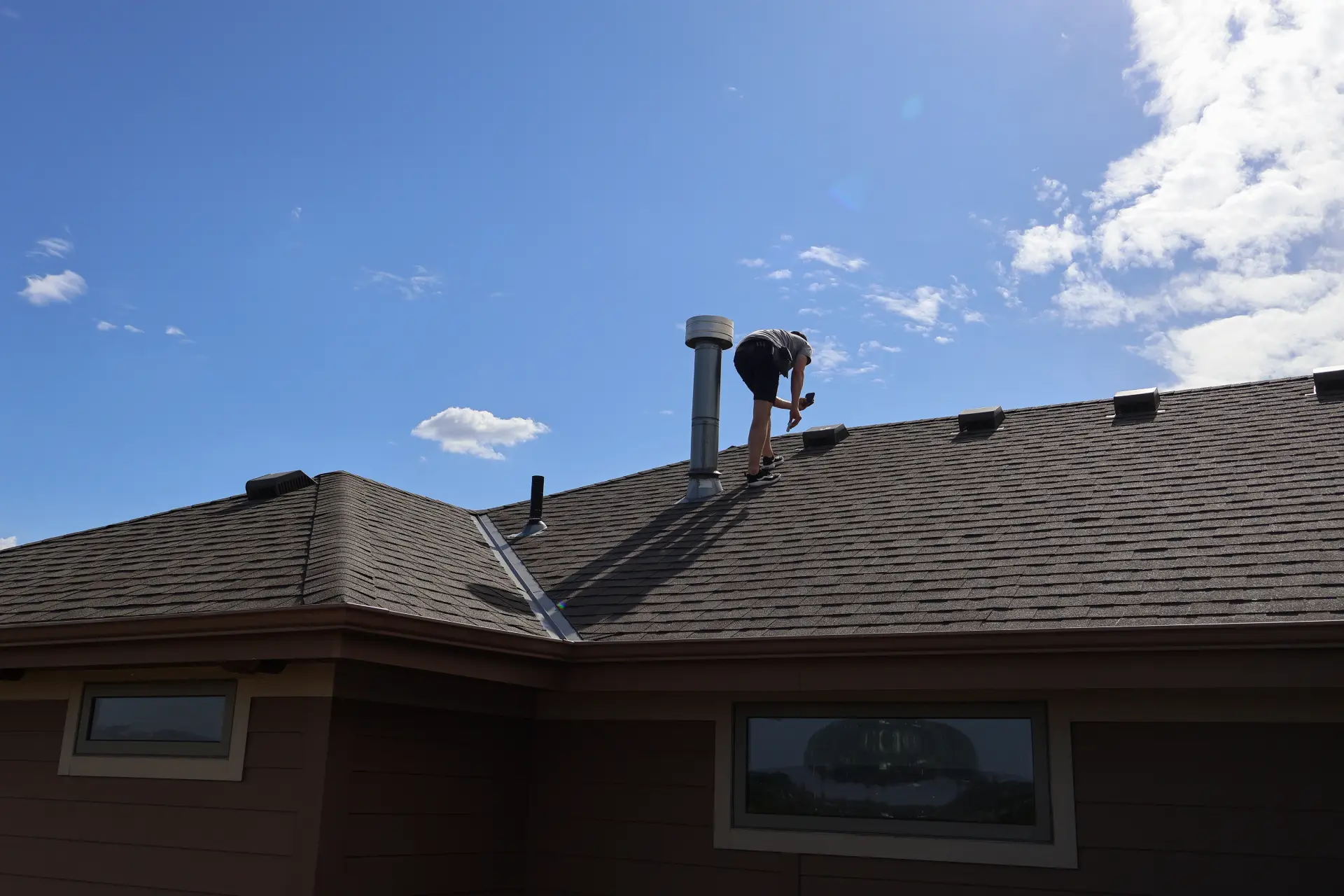 Professional roofer conducting detailed roof inspection in an Omaha home