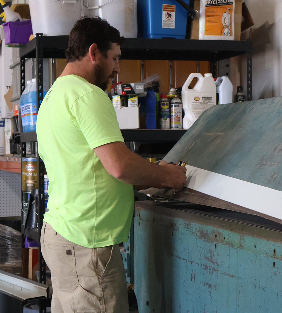 Jeremy Pflug working in the shop and getting measurements
