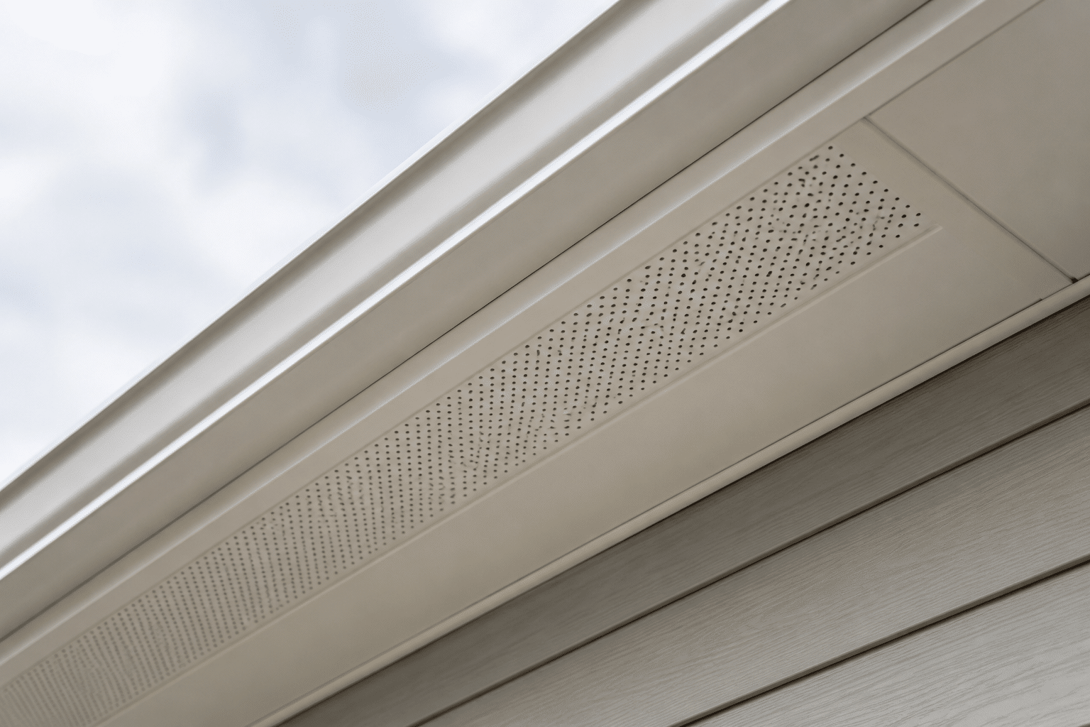 Perforated soffit vent installed beneath roof eaves