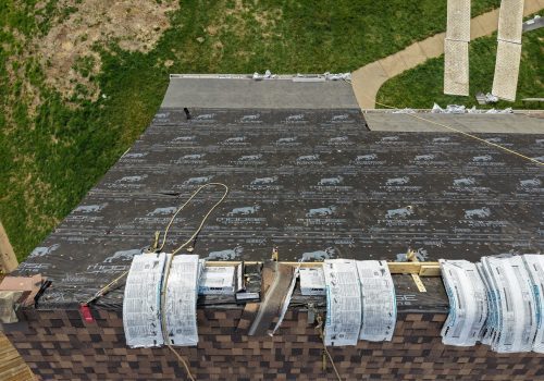 A Wichita roofer is installing new asphalt shingles on a family home