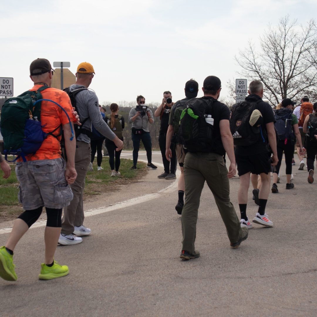 A group of people walking outdoors on a paved path.