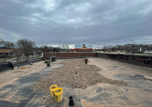 Roof underlayment installation in progress with rolls of material lined up.