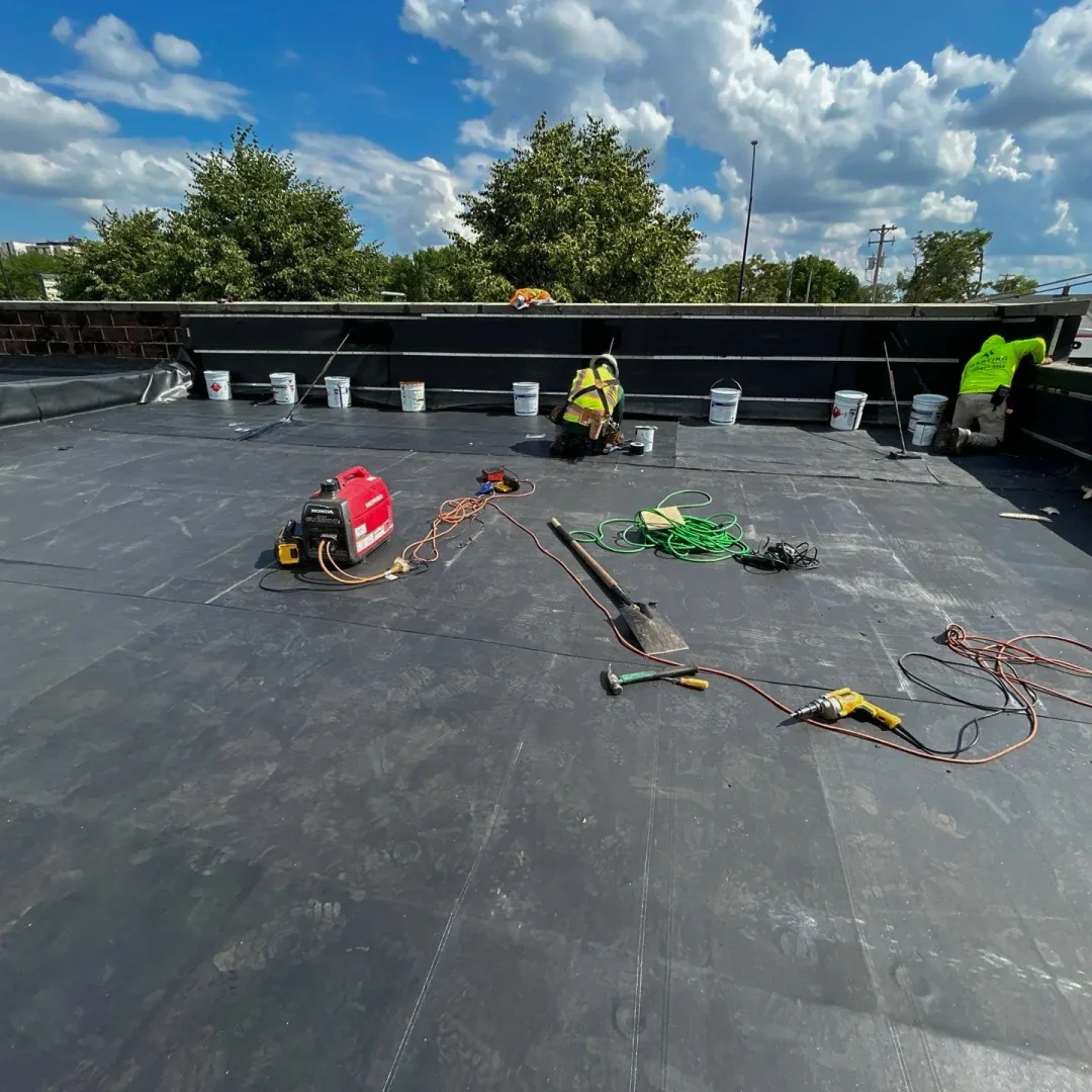 Roof underlayment installation in progress with rolls of material lined up.