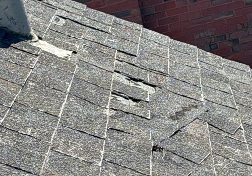 Damaged shingles on a residential roof needing repair or replacement.